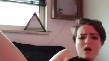 Short haired goth beauty plays with glass dildo